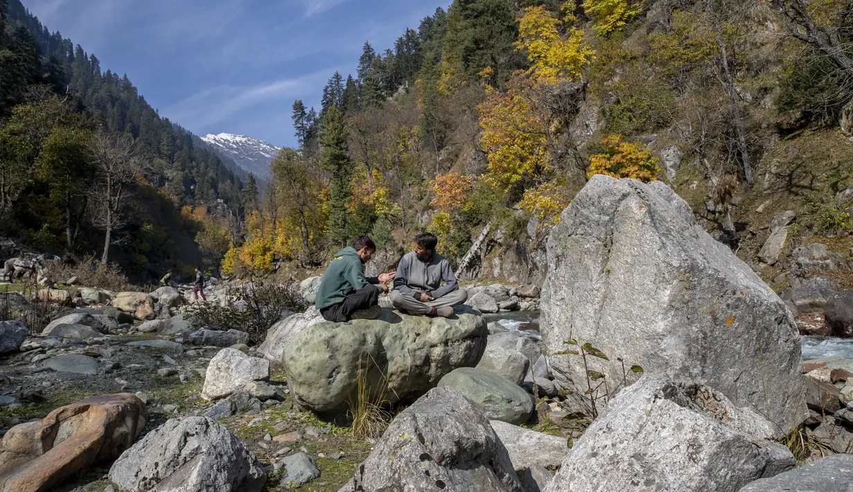 Penunggang kuda Kashmir mengobrol saat mereka menunggu turis di Naranag, utara Srinagar, Kashmir yang dikuasai India (31/10/2021). Di musim dingin, Naranag menerima hujan salju lebat, di mana ski dipraktekkan. (AP Photo/Dar Yasin)