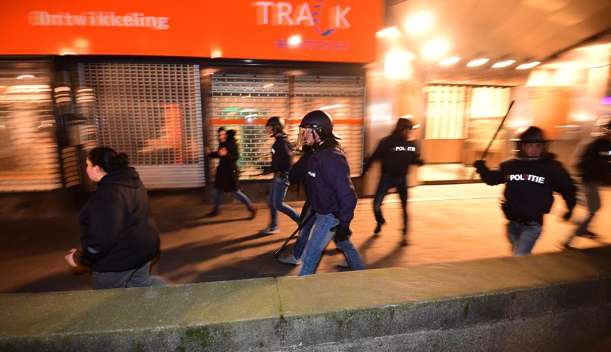 Polisi membubarkan aksi protes yang digelar oleh warga Turki di Rotterdam, Belanda (11/3). Sedangkan PM Belanda Mark Rutte mengatakan negaranya tidak akan pernah bernegosiasi dengan Turki jika di bawah ancaman seperti itu. (AFP/Emmanuel Dunand)