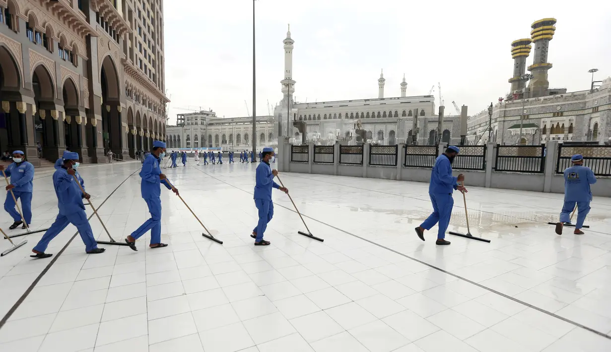 Para pekerja mendisinfeksi lantai di luar Masjidil Haram, Makkah, Arab Saudi, Senin (27/7/2020). Karena pandemi COVID-19, Arab Saudi membatasi jumlah jemaah haji tahun ini hanya untuk sekitar 1.000 orang. (Saudi Ministry of Media via AP) (AP Photo)