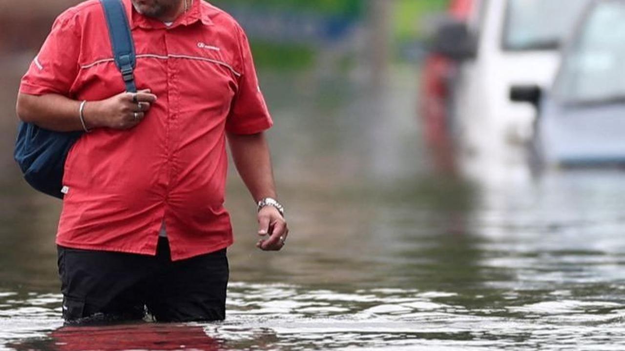 Dari foto-foto ini memperlihatkan jalan raya utama yang tergenang air. Begitu juga dengan kendaraan yang terendam dan pejalan kaki harus berjuang menerobos banjir. Foto: REUTERS / Agustin Marcarian<br>