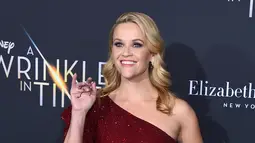 Aktris dan produser Reese Witherspoon berpose untuk fotografer setibanya pada premier film "A Wrinkle In Time" di Los Angeles, Senin (26/2). Wanita 41 tahun ini tampil cantik dengan  gaun berwarna merah marun yang dikenakannya (Jordan Strauss/Invision/AP)