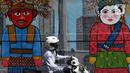 Pengendara sepeda motor melintas di depan mural Kota Jakarta, Tanah Kusir, Kebayoran Lama, Jakarta, Jumat (26/11/2021). Mural tersebut bertemakan Kota Jakarta dengan gambar ikon seperti ondel-ondel, Monas hingga transportasi. (Liputan6.com/Herman Zakharia)