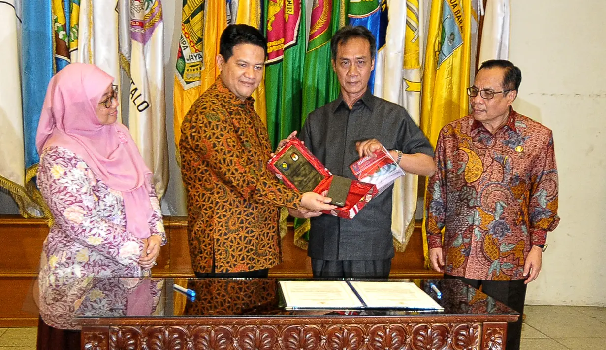 Ketua KPU, Husni Kamil Manik (kedua kiri) bersama Sekretaris Jenderal Kemendagri Yuswandi A. Tumenggung (kedua kanan) berfoto bersama usai penyerahan DP4 Pilkada Serentak 2015 di Kemendagri, Jakarta, Rabu (3/6/2015). (Liputan6.com/Yoppy Renato)
