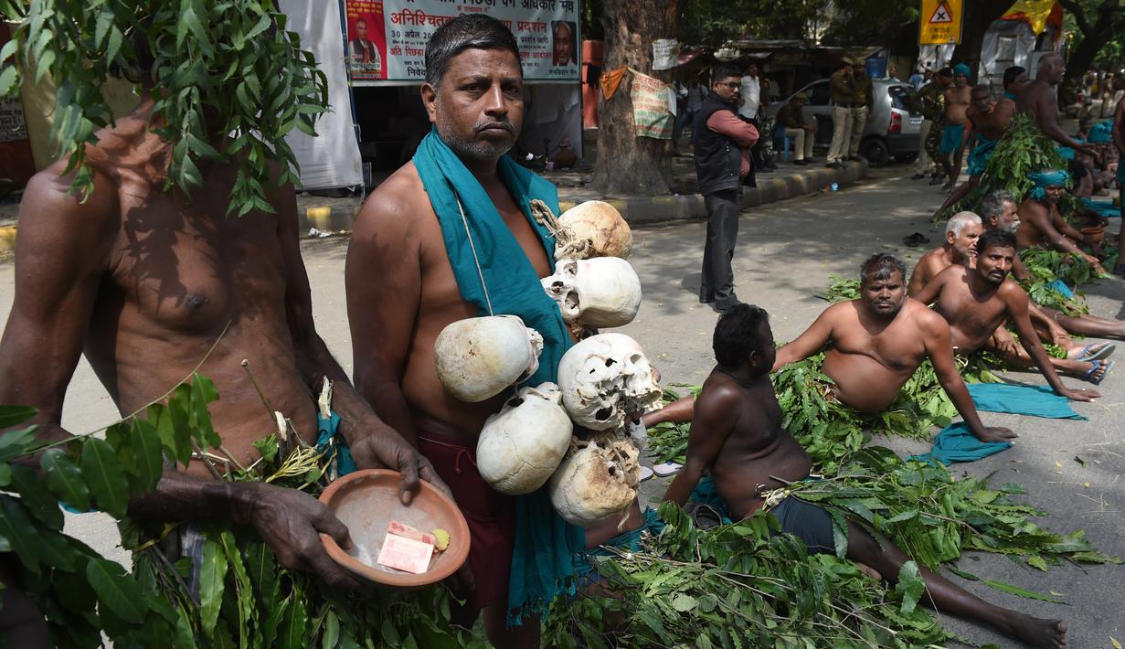Petani Tamil Nadu menggelar unjuk rasa di New Delhi, Kamis (16/3). Lebih dari 200 petani telah melakukan bunuh diri di Tamil Nadu dalam beberapa bulan terakhir setelah gagal panen akibat irigasi dan curah hujan yang buruk. (AFP PHOTO / Prakash SINGH)  