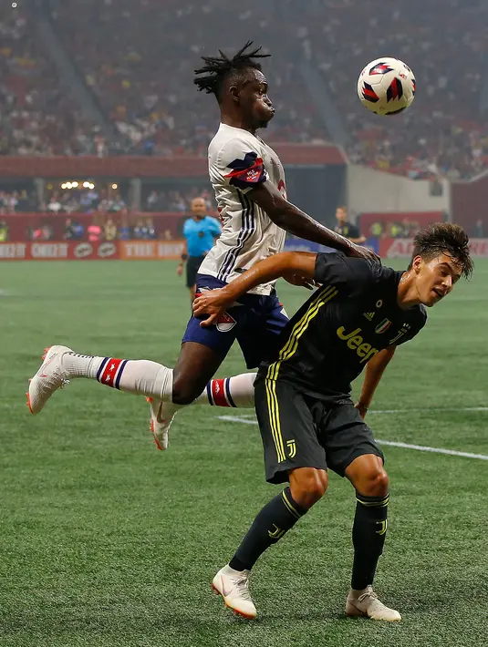 Pemain MLS All-Stars Alberth Elis berebut bola dengan pemain Juventus Pietro Beruatto saat bertanding pada MLS All-Star Game 2018 di Mercedes-Benz Stadion, Atlanta, Georgia (1/8). Juventus menang 5-3. (AFP Photo/Kevin C. Cox)