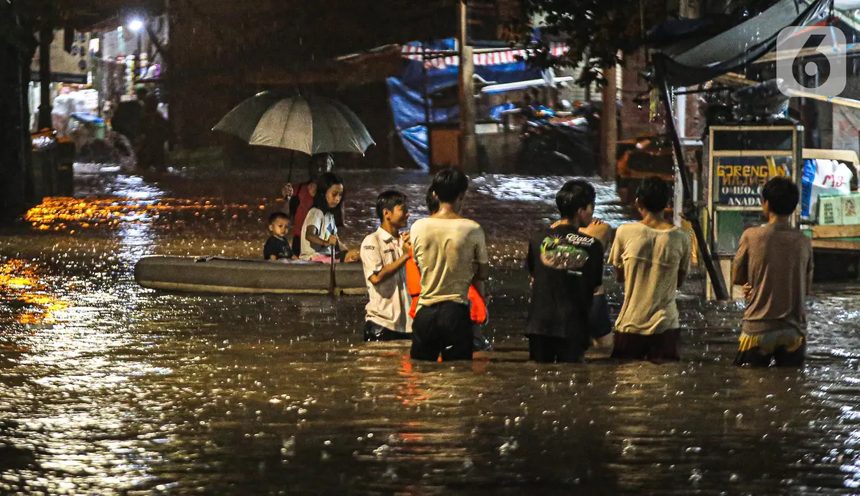Sejumlah warga melintasi genangan banjir di kawasan Kemang, Jakarta, Selasa (4/10/2022). Jalan Kemang Utara IX tak bisa dilalui oleh kendaraan. Banjir menggenangi kawasan Pasar Kambing dan sejumlah rumah penduduk. (Liputan6.com/Faizal Fanani)