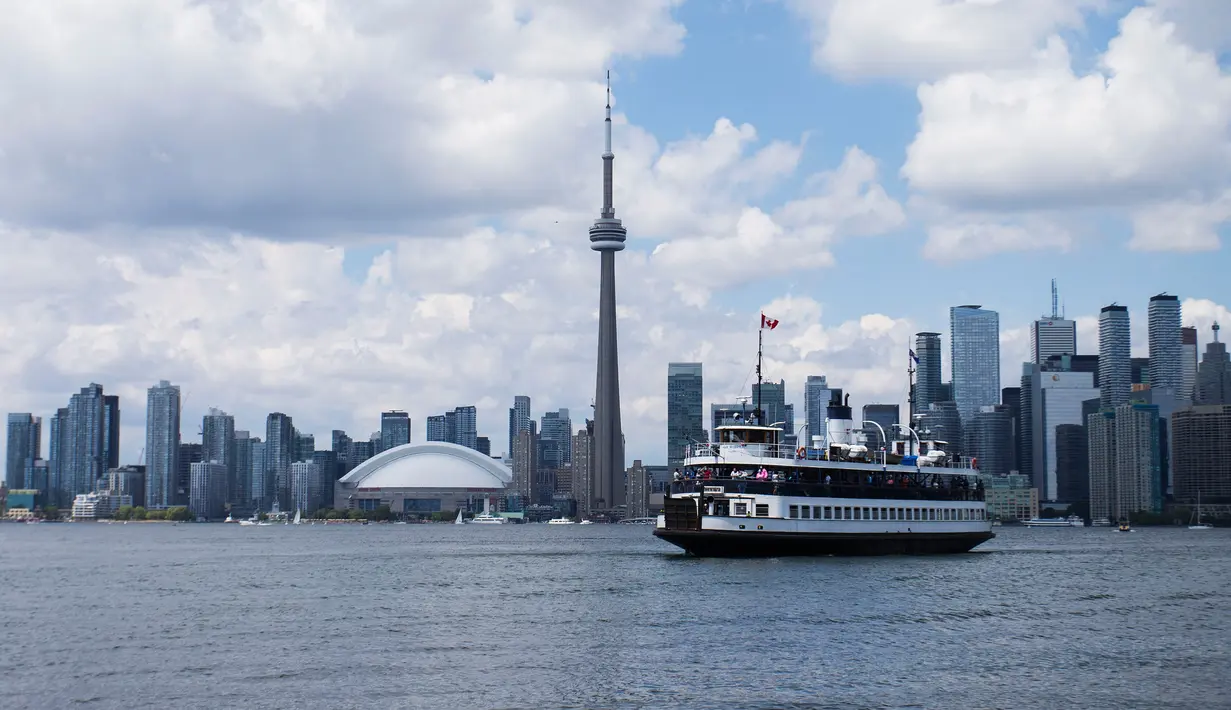 Sebuah kapal feri terlihat di antara Terminal Feri Jack Layton dan Center Island di Danau Ontario di Toronto, Kanada (27/6/2020). Layanan kapal feri menuju Kepulauan Toronto kembali dibuka untuk umum mulai Sabtu (27/6). (Xinhua/Zou Zheng)