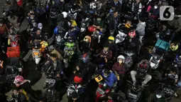 Ratusan pemudik bersepeda motor antre menunggu giliran masuk ke kapal "Roll on-Roll off" (RoRo) di Pelabuhan Merak, Banten, Kamis (28/4/2022). Puncak arus mudik H-3 lebaran di Pelabuhan Merak sudah dipenuhi oleh pemudik. Tampak, pemudik yang membawa anak kecil serta barang bawaan yang diikat di belakang motor. (Liputan6.com/Angga Yuniar)