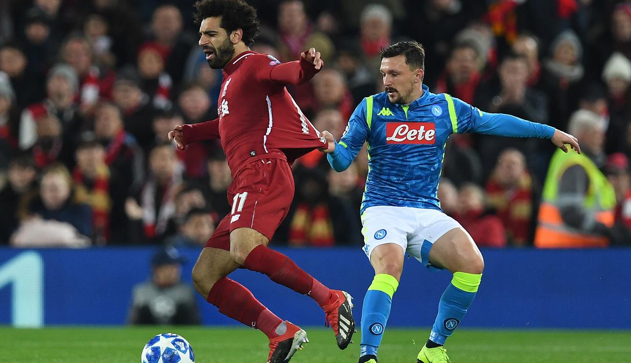 Gelandang Liverpool, Mohamed Salah, berusaha melewati bek Napoli, Mario Rui, pada laga Liga Champions di Stadion Anfield, Liverpool, Selasa (11/12). Liverpool menang 1-0 atas Napoli. (AFP/Paul Ellis)