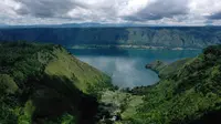 Foto udara yang diambil 4 April 2019 ini menunjukkan Danau Toba dari kawasan Sigapitan, Sumatera Utara. Danau terbesar di Asia Tenggara yang dikelilingi tujuh kabupaten di Sumatera Utara tersebut luasnya hampir dua kali ukuran Negara Singapura. (GOH CHAI HIN / AFP)