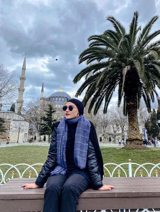 Berpose di belakang masjid Sultan Ahmed, Zee Zee tampil stylish memadukan leather puff jacket, celana jeans, syal, dan turban hitam. (Instagram/zeezeeshahab).