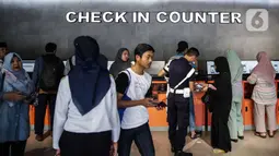Calon penumpang check in mandiri di Stasiun Pasar Senen, Jakarta, Jumat (20/12/2019). PT KAI Daop I Jakarta akan mengoperasikan 13 kereta tambahan jarak jauh untuk mengantisipasi lonjakan penumpang jelang Natal dan Tahun Baru. (Liputan6.com/Faizal Fanani)