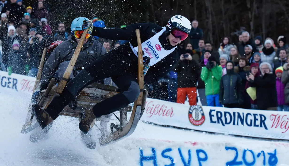 Aksi peserta mengendalikan kereta luncurnya saat mengikuti lomba kereta luncur tanduk tradisional di Desa Bavaria, Garmisch-Partenkirchen, Jerman (6/1). Lebih dari 70 tim mengikuti lomba tersebut. (Angelika Warmuth/dpa via AP)