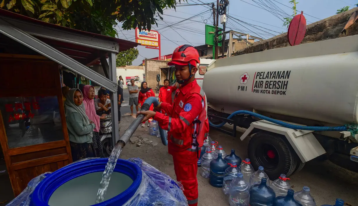 Petugas Palang Merah Indonesia (PMI) mengisi air bersih ke dalam toren air milik warga di RW 08. Cipayung Jaya, Kota Depok, Jawa Barat, Jumat (14/07/2026).