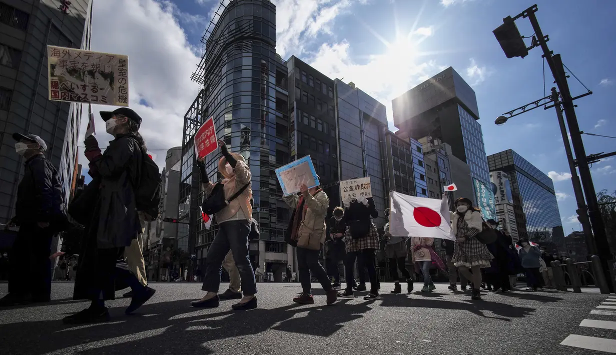 Orang-orang mengambil bagian dalam pawai untuk memprotes pernikahan antara Putri Jepang Mako dan Kei Komuro di Tokyo (26/10/2021). Putri Mako secara resmi kehilangan status kerajaannya setelah menikahi kekasih semasa kuliah, Kei Komuro pada Selasa (26/10). (AFP/Kazuhiro Nogi)