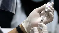 Vaksinator menyiapkan vaksin Covid-19 di halaman Kantor Kecamatan Penjaringan, Jakarta, Kamis (19/8/2021). Vaksinasi malam ini digelar untuk menjangkau warga yang tidak bisa ikut vaksinasi pada siang hari karena bekerja dan alasan lainnya. (Liputan6.com/Helmi Fithriansyah)