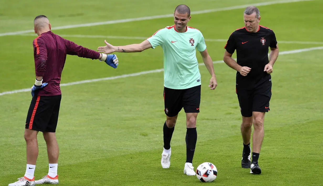 Pemain Portual, Pepe (tengah) bersalaman dengan kiper, Anthony Lopes saat sesi latihan di Marcoussis, outskirts,  Paris, (5/7/ 2016), Portugal akan menghadapi Wales pada semifinal Piala Eropa 2016. (AFP/Francisco Leong)