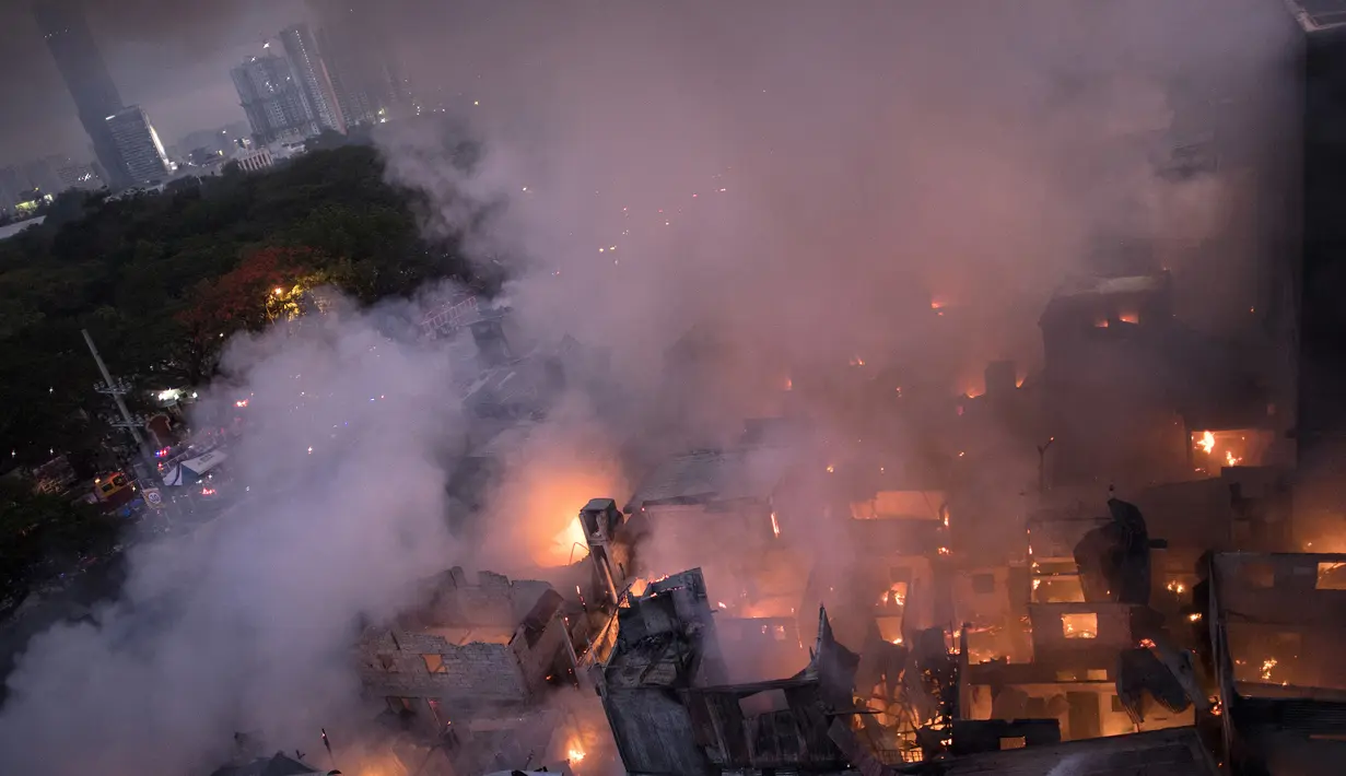 Suasana kebakaran yang melahap daerah kumuh di Manila, Filipina (23/5). Menurut laporan media setempat, kebakaran tersebut menghancurkan 200 rumah yang mempengaruhi 300 keluarga. (AFP Photo/Noel Celis)