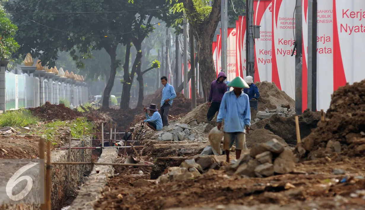 Pekerja melakukan pembuatan saluran air di trotoar Jalan Gerbang Pemuda Senayan, Jakarta, Kamis (25/8). Pengerjaan trotoar dilakukan PPK Gelora Bung Karno (PPKGBK) dan ditargetkan selesai pada akhir 2017. (Liputan6.com/Helmi Fithriansyah)