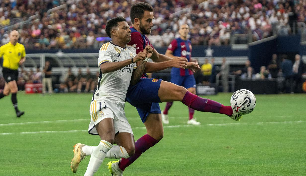 Striker Real Madrid, Rodrygo Silva (kiri) berebut bola dengan bek Barcelona, Eric Garcia pada laga pramusim Soccer Champions Tour 2023 di AT&T Stadium, Arlington, Texas, Minggu (30/7/2023) dini hari WIB. (AP Photo/Jeffrey McWhorter)