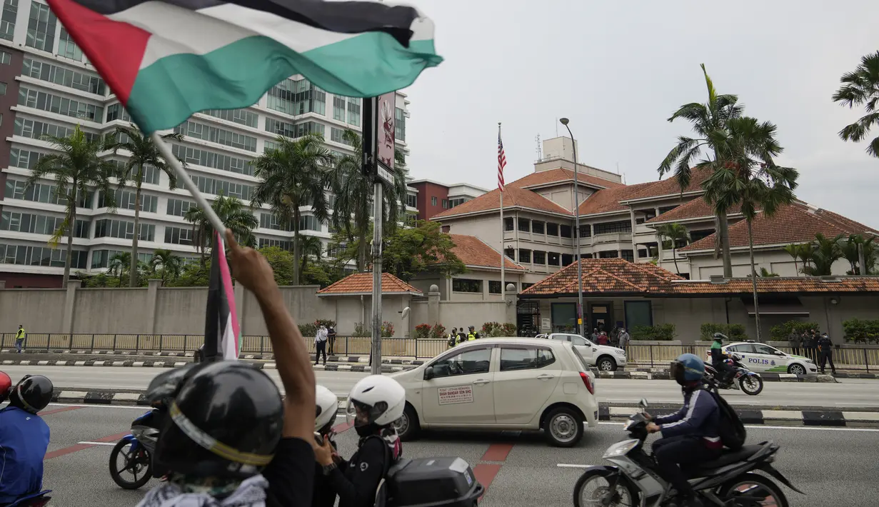 Warga Muslim mengendarai motor membawa bendera Palestina saat konvoi protes menentang serangan Israel di Gaza di luar Kedutaan Besar Amerika Serikat di Kuala Lumpur, Malaysia, Jumat (21/5/2021).  (AP Photo / Vincent Thian)