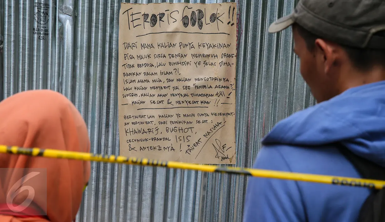 Warga melihat sebuah kertas berisi makian untuk para pelaku teroris di depan Kafe Starbucks, Jalan MH Thamrin, Jakarta, Jumat (15/1). Pamflet berjudul 'Teroris Goblok' itu ditulis dengan tulisan tangan menggunakan spidol. (Liputan6.com/Faizal Fanani)