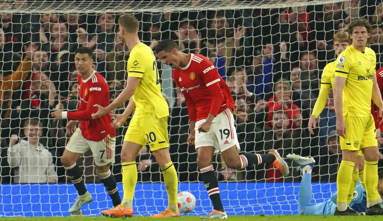 <p>Pemain Manchester United Raphael Varane (tengah) melakukan selebrasi usai mencetak gol ke gawang Brentford pada pertandingan sepak bola Liga Inggris di Stadion Old Trafford, Manchester, Inggris, 2 Mei 2022. Manchester United menang 3-0. (AP Photo/Jon Super)</p>