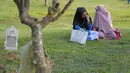 Dua perempuan Aceh berdoa di pemakaman massal Ulhee Lheue, Banda Aceh, Sabtu (26/12/2015).  Doa tersebut untuk keluarga mereka yang terkena bencana Tsunami pada 26 Desember 2014. (AFP Photo/ Chaideer Mahyuddin)