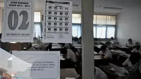 Para siswa mengikuti pelaksanaan Ujian Nasional SMP Sederajat di SMP Terbuka 48, Jakarta, Senin (5/5/14). (Liputan6.com/Johan Tallo)