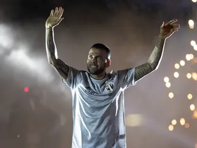 Bek Dani Alves menyapa para suporter saat diperkenalkan sebagai bek baru Sao Paulo di stadion Morumbi, Brasil (6/8/2019). Mantan pemain Barcelona dan Juventus berusia 36 tahun ini dikontrak selama tiga musim, atau hingga 2022. (AP Photo/Andre Penner)