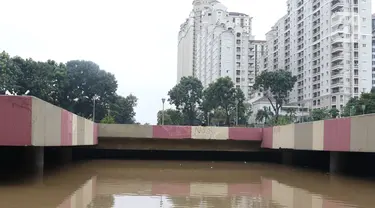 Warga melihat banjir yang mengenangi underpass Kemayoran, Jakarta, Minggu (2/2/2020). Banjir kembali merendam underpass Kemayoran, Jakarta Pusat. Akibatnya, akses jalur tersebut pun terputus alias tak bisa dilalui kendaraan. (Liputan6.com/Angga Yuniar)