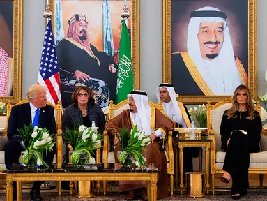 Presiden AS Donald Trump didampingi Melania Trump saat menemui Raja Arab Saudi Salman bin Abdulaziz al-Saud di Riyadh (20/5). Kunjungan ini merupakan kunjungan luar negri Trump pertama sebagai Presiden AS. (AFP/Saudi Royal Palace/Bandar Al-Jalou)