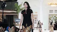 Penampilan Yuki saat berjalan di atas panggung catwalk mengenakan kebaya kutu baru hitam dengan kombinasi celana bermotif. (Liputan6.com/IG/@yukikt)