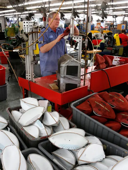 Pekerja menyelesaikan proses pembuatan bola american football di pabrik Wilson Sporting Goods di Ada, Ohio, AS (23/1). (AP Photo / Charles Rex Arbogast)