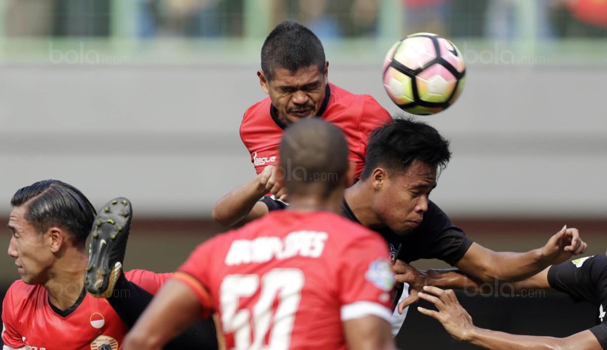 Striker Persija, Bambang Pamungkas, duel udara dengan pemain Persegres pada laga Liga 1 Indonesia di Stadion Patriot, Bekasi, Sabtu (14/10/2017). Persija menang 5-0 atas Persegres.(Bola.com/M Iqbal Ichsan)