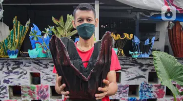 Seorang anak muda menunjukkan pot tanaman berbahan dasar kain bekas di  Cibodas, Kota Tangerang, Minggu (3/10/2021). Para pemuda di kawasan tersebut memanfaatkan PPKM untuk membuat Pot tanaman daur ulang yang dipasarkan mulai harga Rp. 30 ribu hingga Rp. 80 ribu. (Liputan6.com/Angga Yuniar)