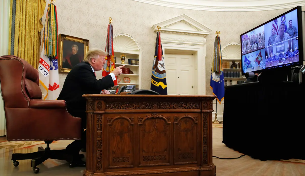 Presiden AS Donald Trump berbicara dengan prajurit militer melalui konferensi video di Gedung Putih, Selasa (25/12). Prajurit tersebut ditempatkan di Guam, Qatar, Alaska, dan dua kelompok di Bahrain. (AP Photo/Jacquelyn Martin)