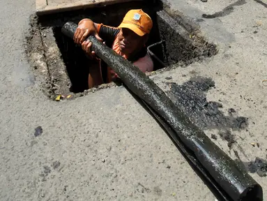 Petugas PPSU menemukan kulit kabel di gorong-gorong saluran air Jalan Gatot Subroto, Jakarta Selatan, Senin (6/3). Kulit kabel ini dianggap menjadi penyebab utama terjadinya banjir di Jalan Gatot Subroto pada 2 Maret 2017 lalu. (Liputan6.com/Johan Tallo)