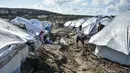 Para migran menggali di sekitar tenda setelah hujan badai di kamp pengungsi Kara Tepe, di pulau Lesbos, Yunani (14/10/2020).  Sekitar 7.600 pengungsi dan migran telah menetap di kota tenda baru setelah kebakaran berturut-turut pada tanggal 14 September. (AP Photo/Panagiotis Balaskas)
