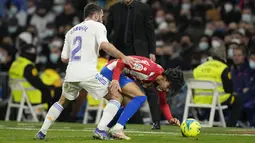 Bek Real Madrid Dani Carvajal berebut bola dengan penyerang Atletico Madrid Joao Felix pada pekan ke-17 Liga Spanyol di Santiago Bernabeu, Senin dini hari WIB (13/12/2021). Real Madrid berhasil menaklukkan rival sekotanya Atletico Madrid dengan skor 2-0. (AP Photo/Bernat Armangue)