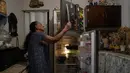 Carmen Castro menunjukkan betapa sedikit makanan di lemari esnya, di tengah pandemi corona di Caracas, Venezuela, 18 Agustus 2021. Castro, 78 tahun, mengatakan sang putri yang berangkat ke Chile tiga tahun lalu mengirimkan uang untuk menambah pensiunnya yang sedikit. (AP Photo/Ariana Cubillos)