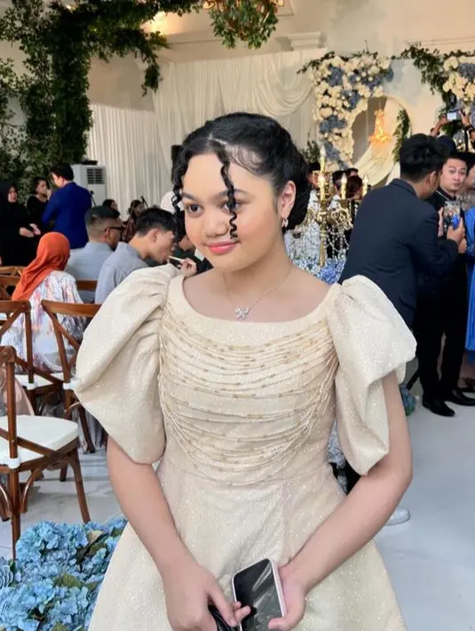 Memasuki usia remaja, wajah Amora pun semakin manis. Ia mengaplikasikan blush on coral dan lipstik pinknya. Rambut keritingnya disanggul sleek dengan sedikit poni belah dua. [@anggi30_]