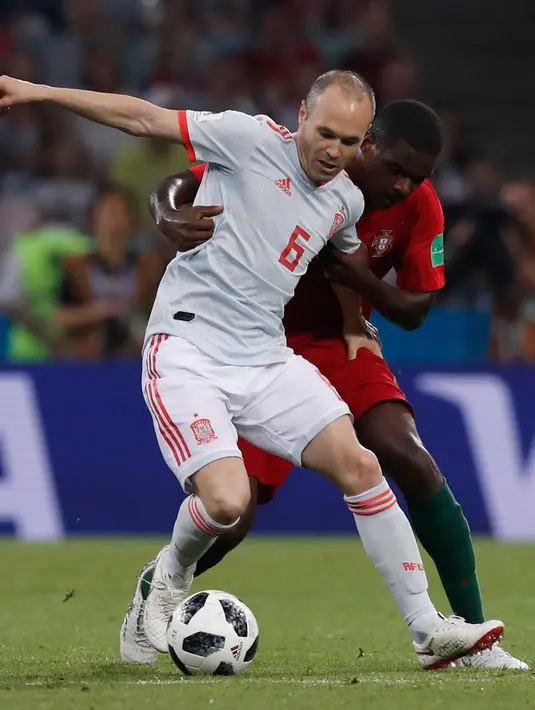 Gelandang Spanyol, Andres Iniesta berusaha mengontrol bola dari kawalan peman Portugal William saat bertanding pada grup B Piala Dunia 2018 di Stadion Fisht di Sochi, Rusia (15/6). Portugal dan Spanyol bermain imbang 3-3. (AP Photo/Manu Fernandez)