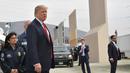 Presiden AS, Donald Trump meninjau prototipe tembok perbatasan AS dan Meksiko yang kontroversial di San Diego, Selasa (13/3). Prototipe tembok perbatasan Trump memiliki tinggi sekitar 9 meter, dengan puncak yang tebal dan bundar. (MANDEL NGAN / AFP)