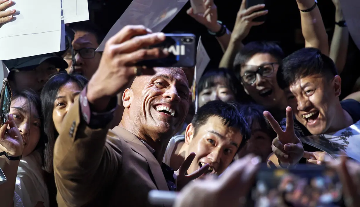 Aktor Dwayne Johnson berswafoto bersama penggemar selama acara red carpet dalam premiere film 'Fast & Furious: Hobbs & Shaw' di Beijing, China, Senin (5/8/2019). Hobbs and Shaw menempatkan dua aktor laga papan atas, Jason Statham dan Dwayne Johnson sebagai pemeran utama. (AP Photo/Andy Wong)