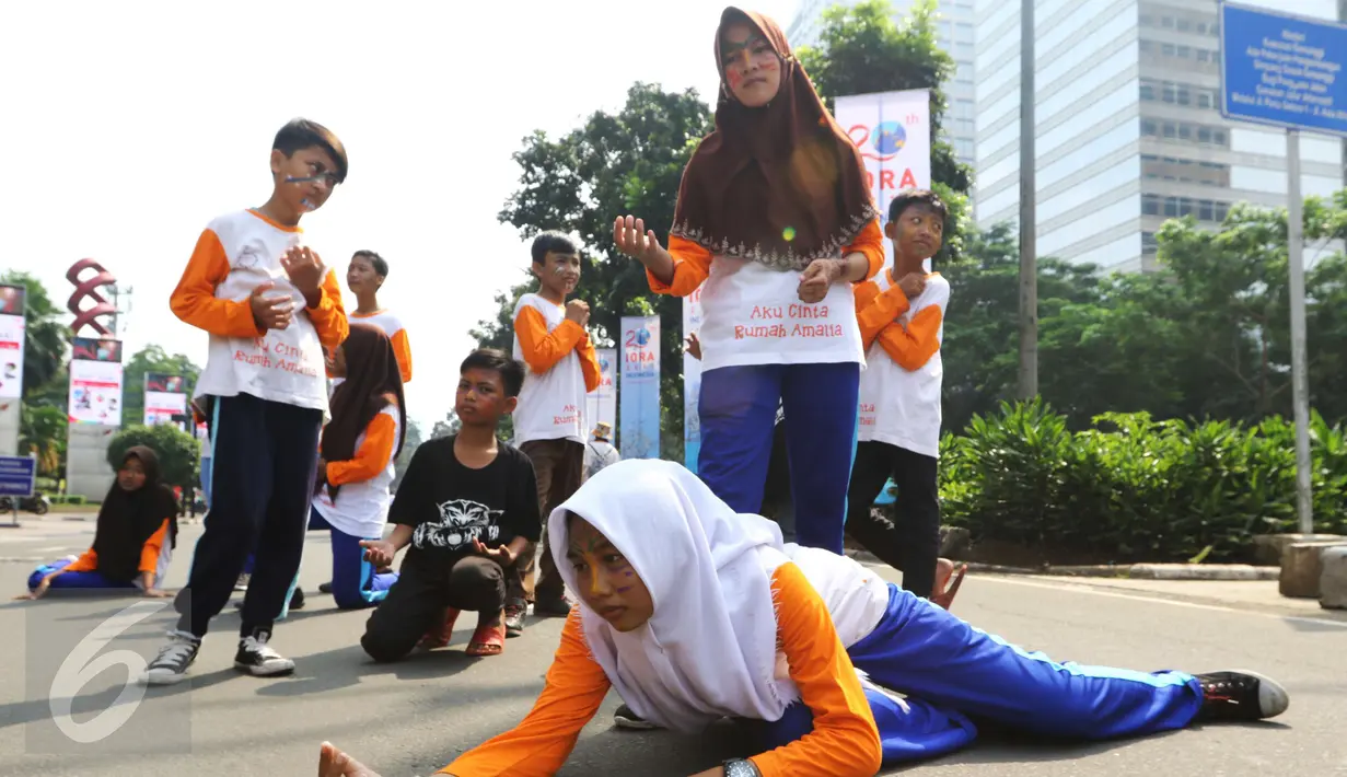 Aksi sejumlah anak-anak dari rumah belajar dan berkarya Rumah Amalia yang melakukan pementasan teater dikawasan Jalan Sudirman pada Hari Bebas Kendaraan Bermotor (HBKB) atau Car Free Day (CFD) di Jakarta, Minggu (5/3). (Liputan6.com/Helmi Afandi)