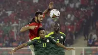 Penyerang Mesir Marwan Hamdi melompat untuk merebut bola dari bek Senegal Abdou Diallo pada pertandingan final Piala Afrika 2021 di Paul Biya Stadium, Kamerun, Senin (7/2/2022) dini hari WIB. Sadio Mane membawa Senegal mengalahkan Mesir lewat adu penalti dengan skor 4-2. (AP Photo/Sunday Alamba)