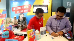 Vice President Credit Cards Group Bank Mandiri mengisi formulir  pendaftaran layanan Internet GIG disaksikan CCO GIG by Indosat Ooredoo Bayu Seto pada acara Mandiri Shopping Deals Bazaar di Senayan City Jakarta, Jumat (8/3). (Liputan6.com/Fery Pradolo)