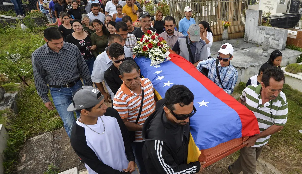 Keluarga dan kerabat mengantarkan jenazah Jose Francisco Guerrero untuk dimakamkan di San Cristobal, Tachira State, Venezuela (19/5). Jose Francisco Guerrero adalah remaja 15 tahun yang tewas ditembak saat kerusuhan di Venezuela. (AFP/Luis Robayo)