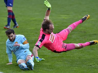 Lionel Messi (kiri) berusaha menjangkau bola dari adangan kiper Eibar, Marko Dmitrovic pada lanjutan La Liga Santander di Ipurua stadium,  Eibar, (17/2/2018). Barcelona menang 2-0. (AFP/Ander Gillenea)